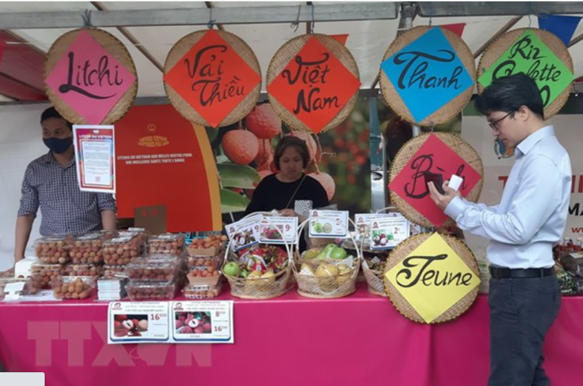 Nhân viên của Công ty Thanh Bình Jeune giới thiệu và bán vải thiều Việt Nam tại Lễ hội ẩm thực Việt Nam tại Pháp, ngày 19/6 vừa qua (Ảnh: Toàn Trí/TTXVN)
